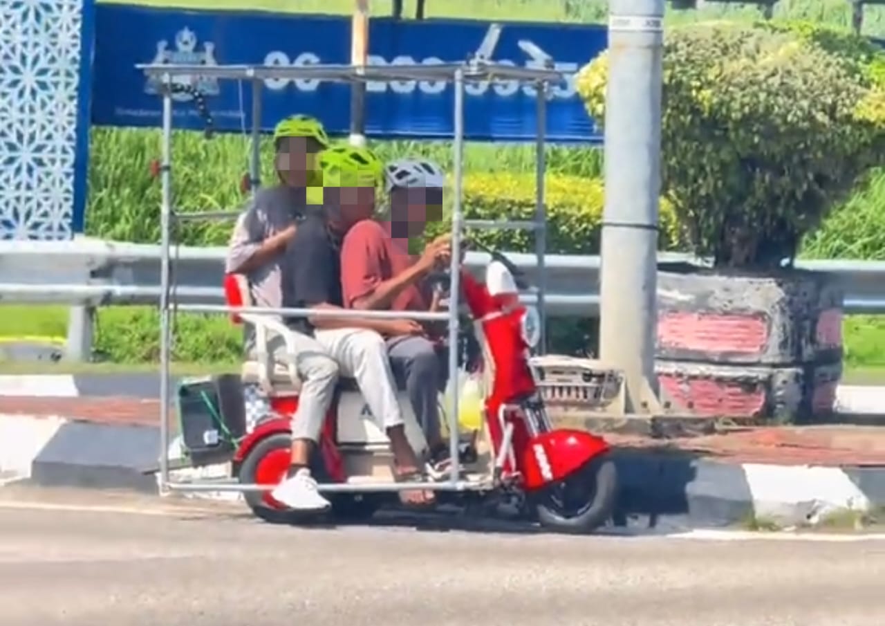 Tangkap layar klip video tular memaparkan tiga individu menaiki kenderaan mikromobiliti di jalan raya di Melaka