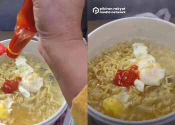 Wanita selamba masak mi segera dalam kereta api